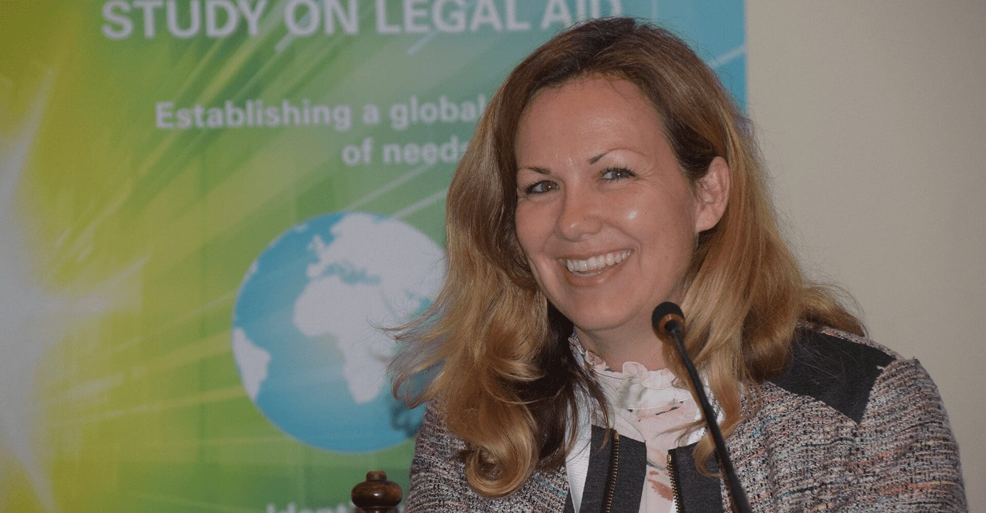 Smiling woman speaking at a conference podium